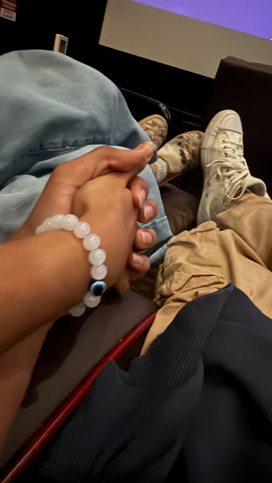 Holding hands together on our first date at the movies